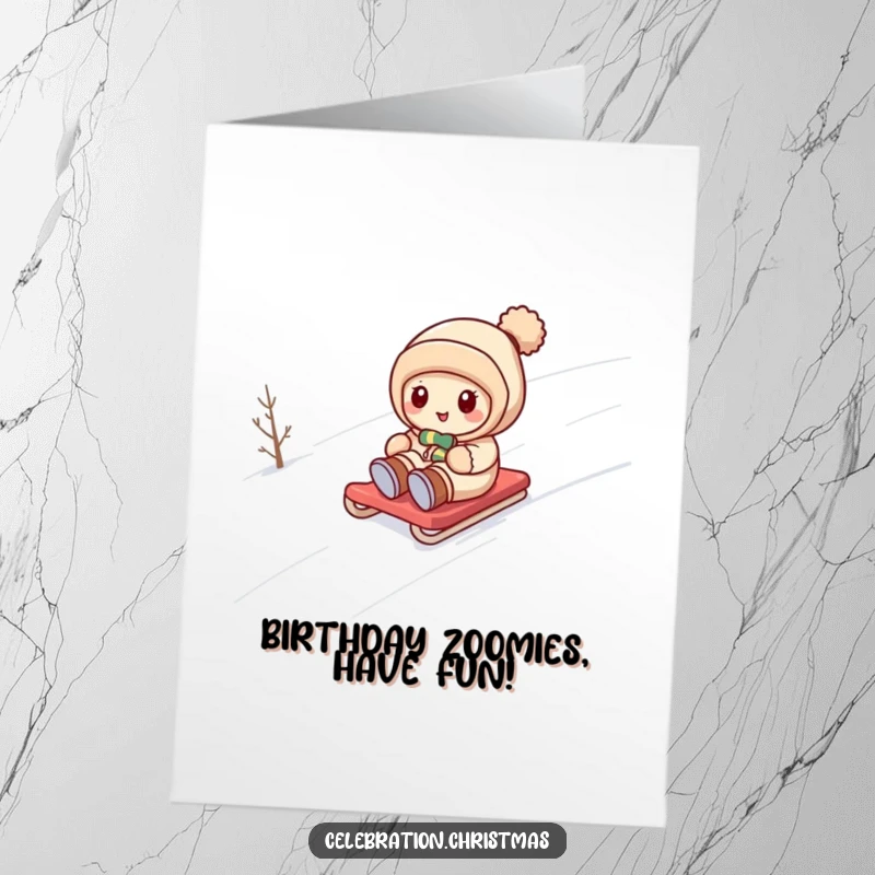 Funny Free Printable Birthday Card: Kawaii character joyfully sledding down a snowy hill, embracing winter fun.